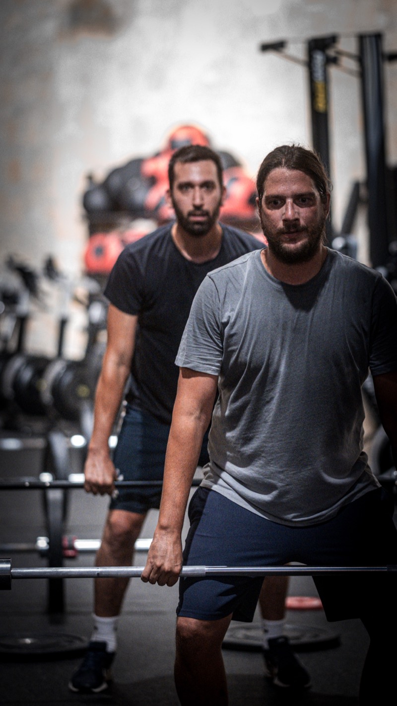 Two members set at the barbell before a lift at CrossFit IRONSKY.